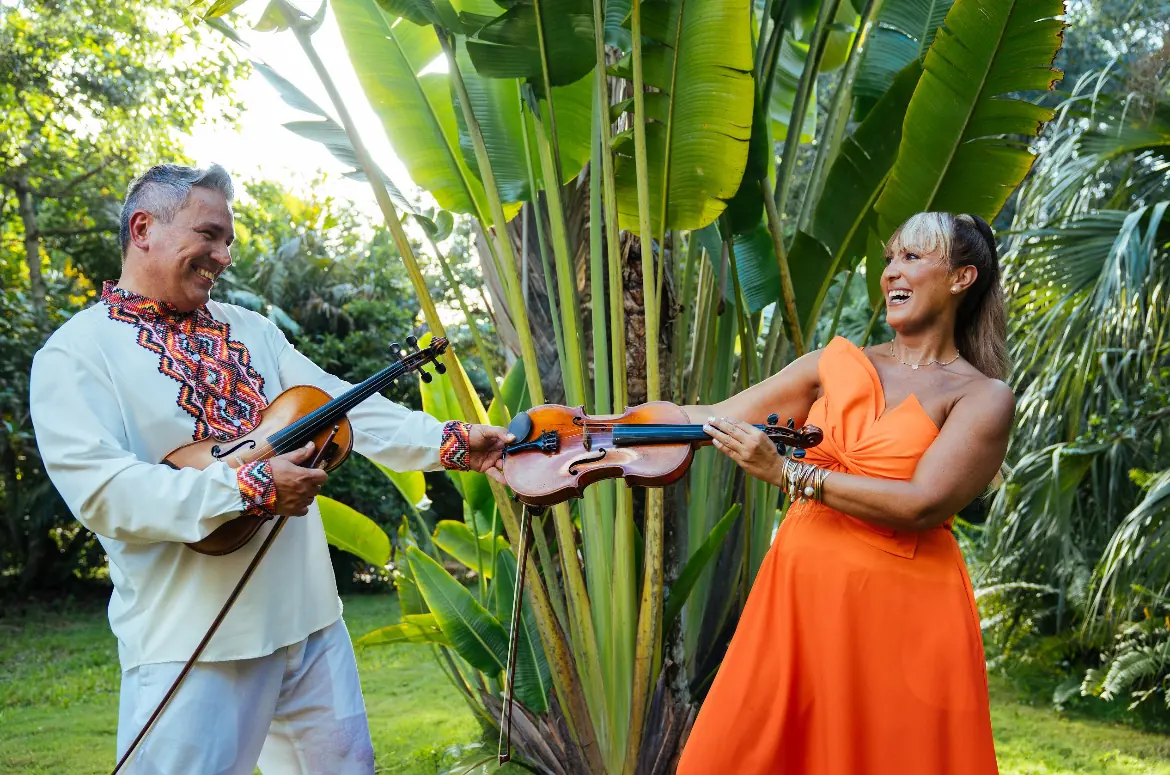 Tania and Abraham playing violin together among banana leaves