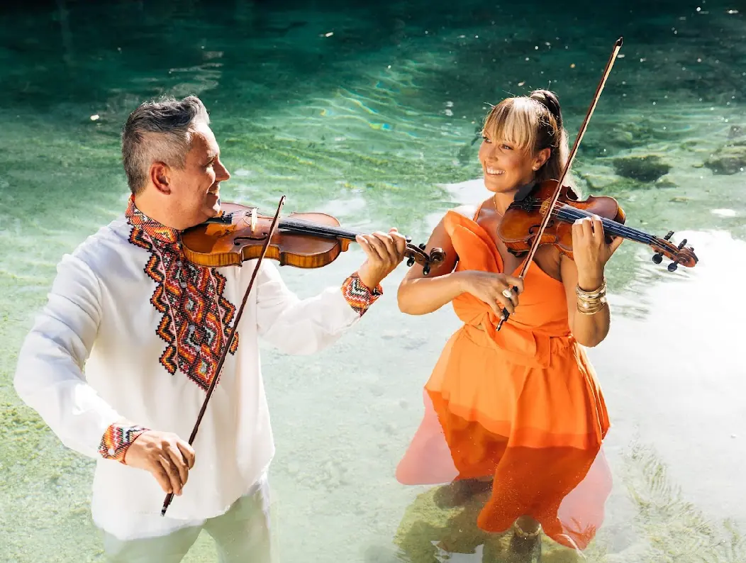 Tania and Abraham playing violin in the river, on the set of “Oshun Yesá”